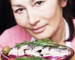 Woman chef offers a dish of salted herring with vegetables